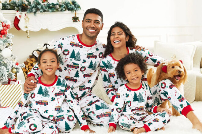 family posing under a christmas tree in matching Christmas Pyjamas