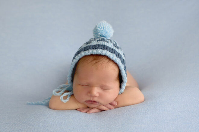 Newborn baby sleeping in blue hat Greek baby name