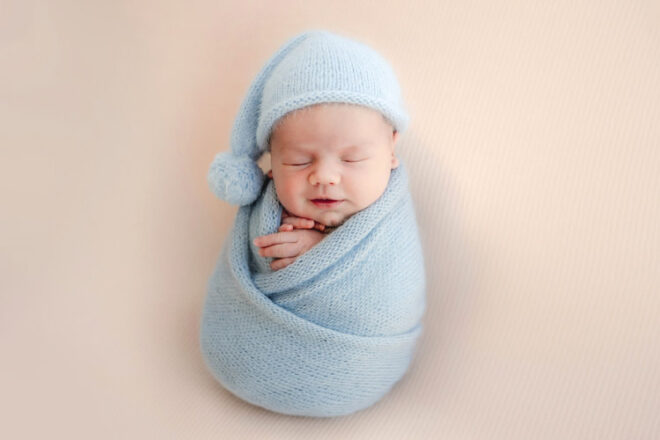 Portrait of newborn baby sleeping swaddled in a blanket