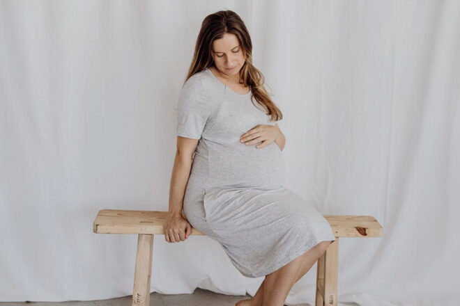 A pregnant woman wearing the Bubba Bump 3 in 1 labour, delivery and nursing gown