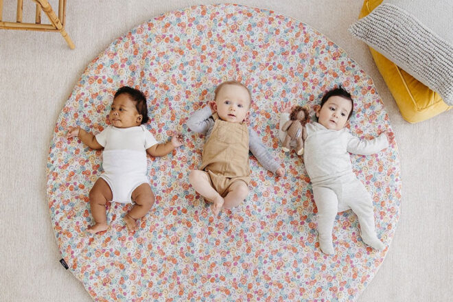 Three babies lying on a Marmalade Lion Baby Play mat 