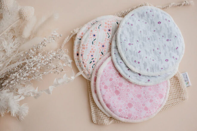 Close up showing My Little Gumnut Reusable breast pads in three floral prints with a storage/wash bag, a gift idea for a new mum survival kit.