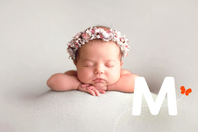 Newborn baby girl asleep with a floral wreath head piece
