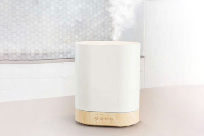 Aroma Haven Humidifer diffuser sitting in a bathroom bench with lots of white steam rising from the unit.