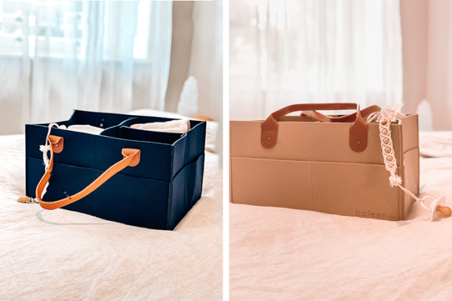 Side views of two B Clean diaper caddies on a bed, showing different colours in navy and tan as well as carry handles.