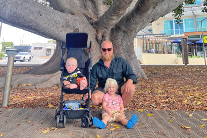 Family posing with Karion Kids Travel Stroller while on holiday