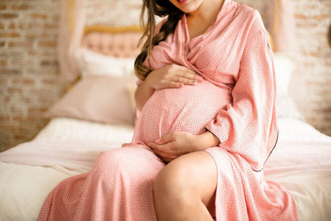 The pregnant woman waiting for her baby Image of pregnant woman touching her belly with hands