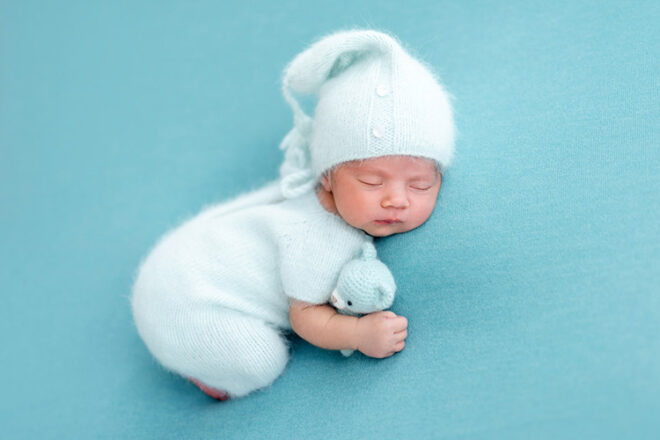 Newborn baby asleep on blue background