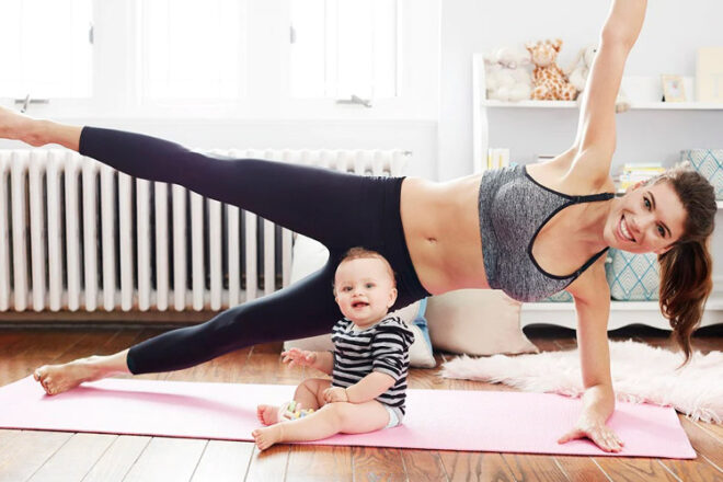 Mother doing yoga in a Bravado Designs Body Silk Seamless Yoga Nursing Bra with baby sitting on floor
