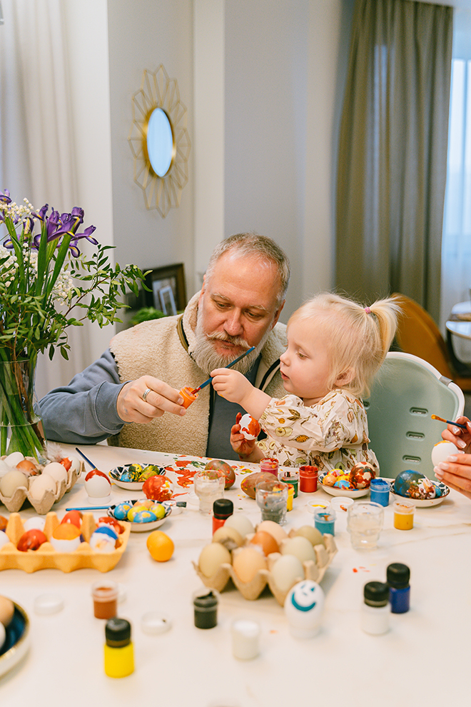 Grandfather and grandchild decorating Easter eggs