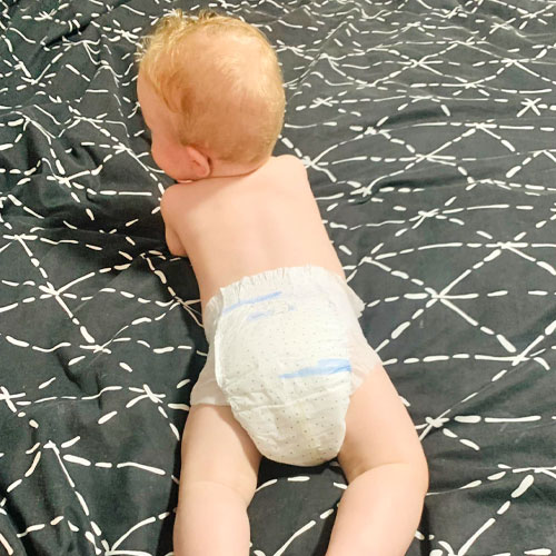 Toddler wearing Coles CUB nappy lying on bed