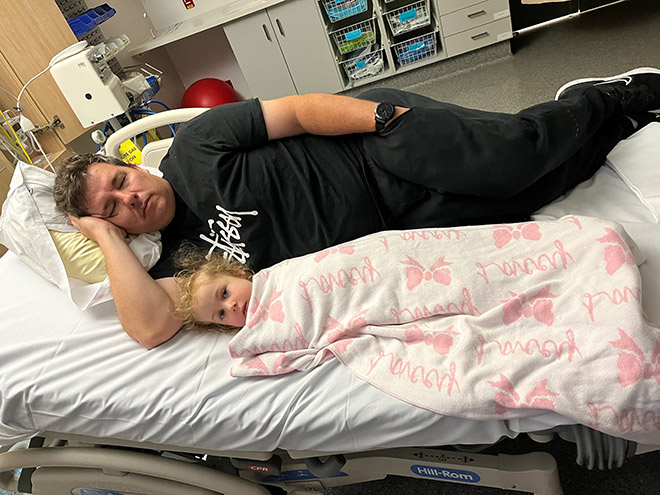 Mindy's husband and daughter asleep in hospital waiting for the new baby to arrive
