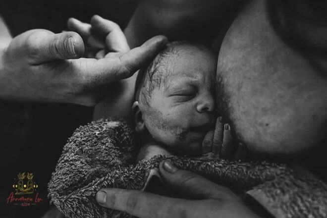 Newborn snuggling into mother's breast