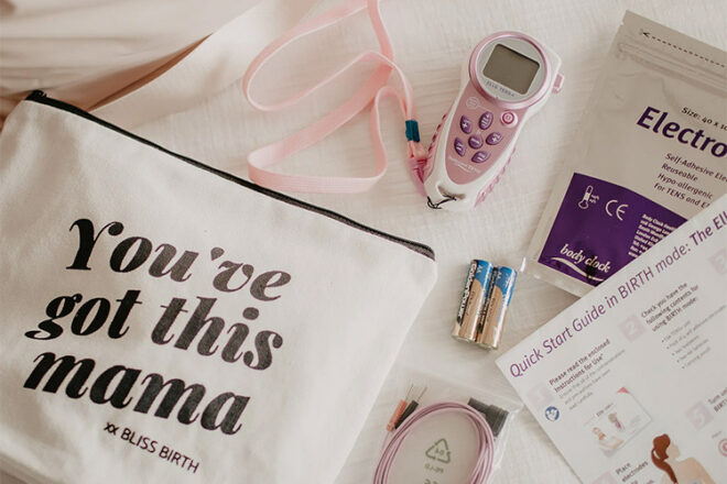 Bliss Birth bag and contents showing pink Elle tens machine with batteries and cables
