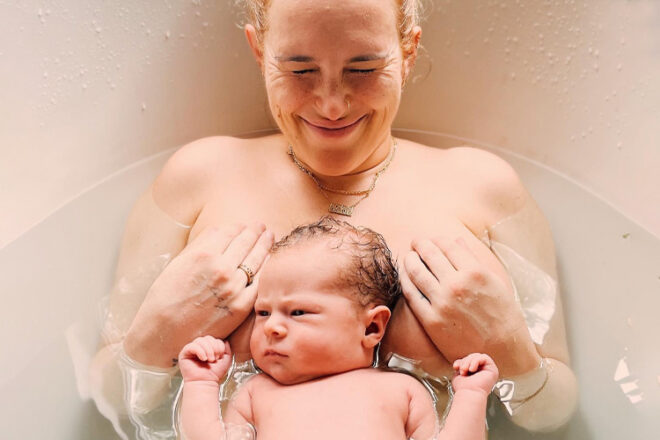 Rumer Willis with her baby Louetta laying on her chest in the bath