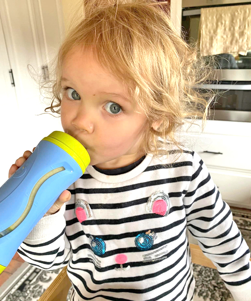 Toddler drinking Optivance Toddler Smoothie out of a bottle