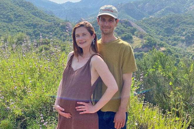 Actress Bonnie Wright and husband Andrew Lococo standing in a field for their pregnancy announcement