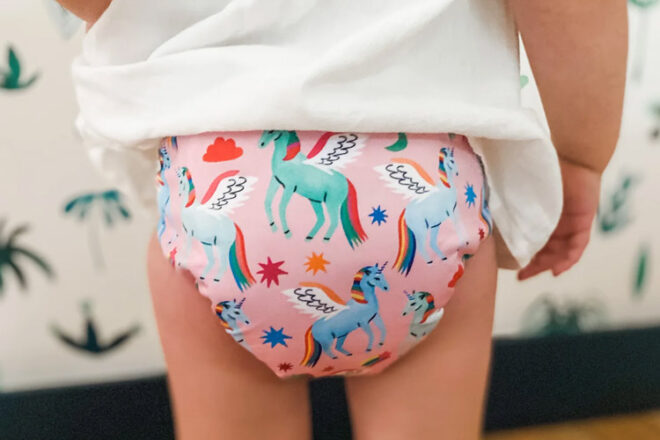 Young girl wearing Cloth & Crown Reusable Cloth Nappies showing flying unicorn pattern