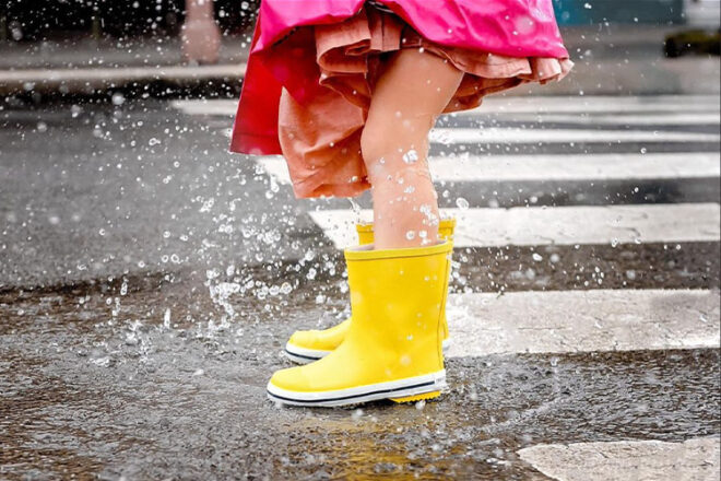 Young girl wearing french soda gumboots in yellow showing her splashing water around