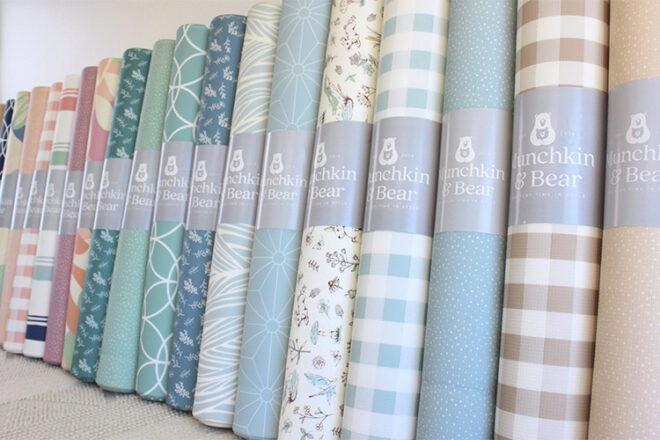 Rolled up Munchkin & Bear Padded Mats showing a huge range of colours and prints for comparison. 