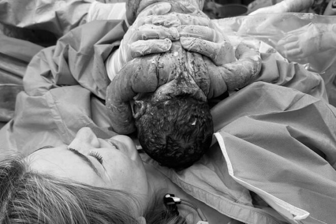 Mother holding her baby during a maternal assisted c section