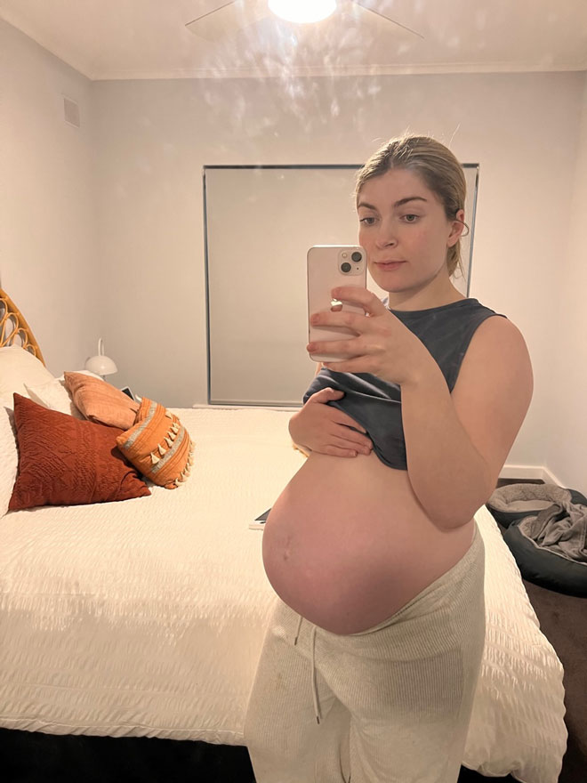 Olivia taking a selfie showing her pregnant belly