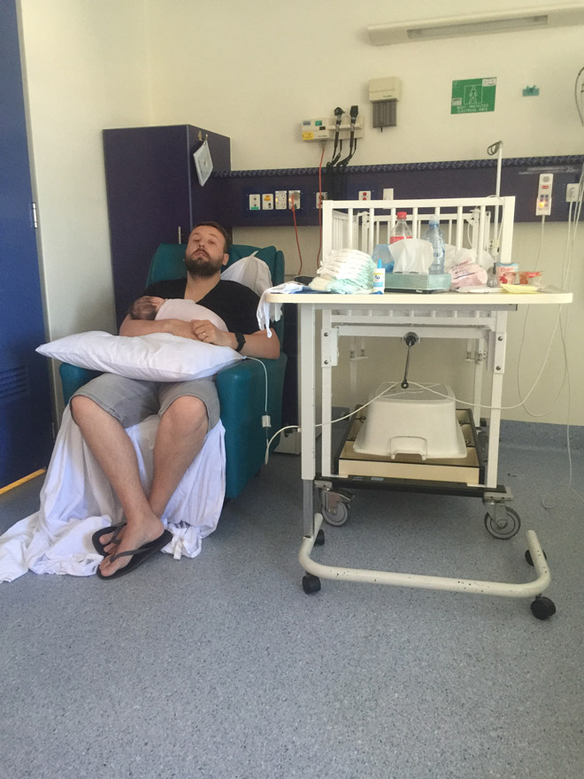 A dad holds his newborn in hospital