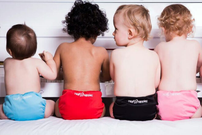 Four babies sitting at piano in Real Nappies Reusable Cloth Nappies showing available colours