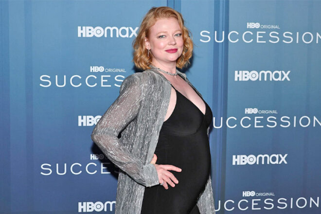 Actress Sarah Snook posing with her baby bump showing in a tight black dress