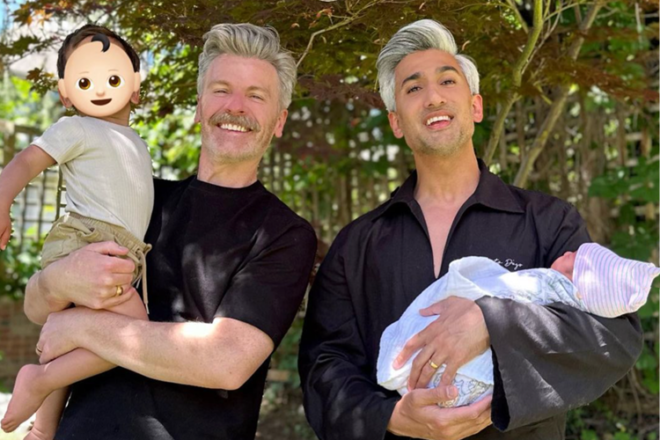 Stylist Tan France holding his newborn baby boy next two husband and other son