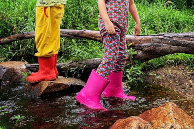 Demar kids lightweight gumboots in the river showing pink and orange colours 