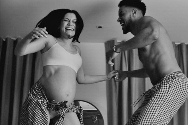 Pregnant Jessie J with partner Chanan jumping on the bed smiling