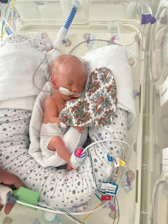a tiny baby in hospital crib