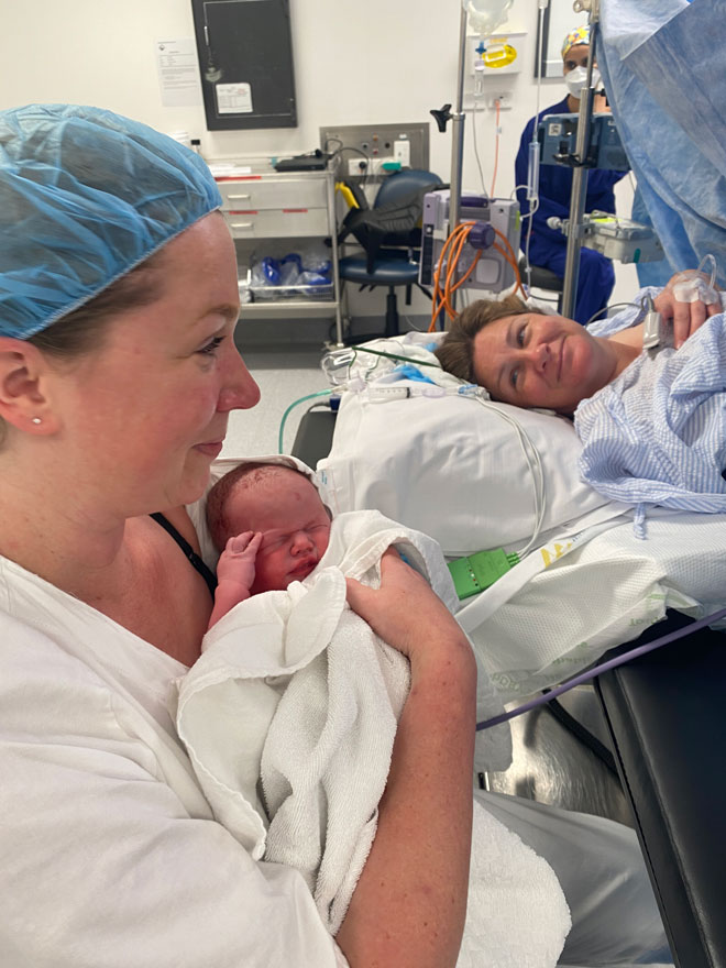 Danni holds her baby for the first time as Lisa smiles