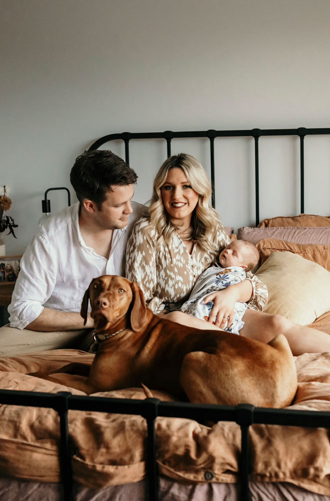 A family portrait at home with Ryan, Ellin, their baby and dog