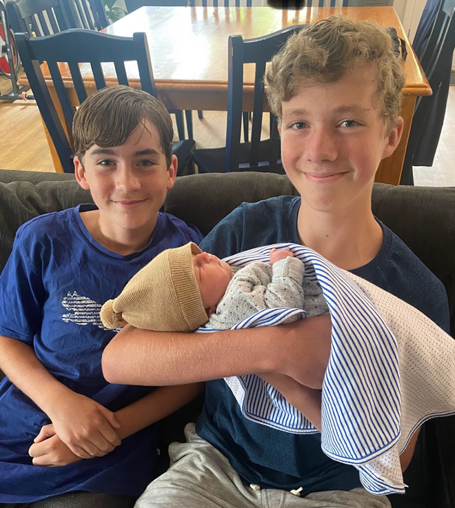 two older brothers holding baby james