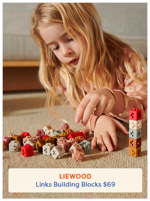 young girl playing with Liewood stacking blocks