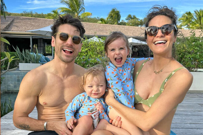 Bachelor couple Matty J and Laura Byrne posing with their two daughters on the beach in Fiji