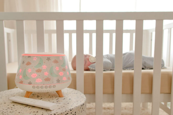 Baby sleeping in their crib next to the Lively Living Aroma Snooze Plus
