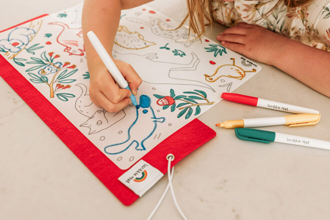 girl colouring in a scribble mat