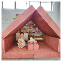 Child sitting in a Whatsie play couch shaped like a tent