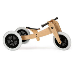Wishbone Original Bike in a natural wooden colour with black and white wheels.