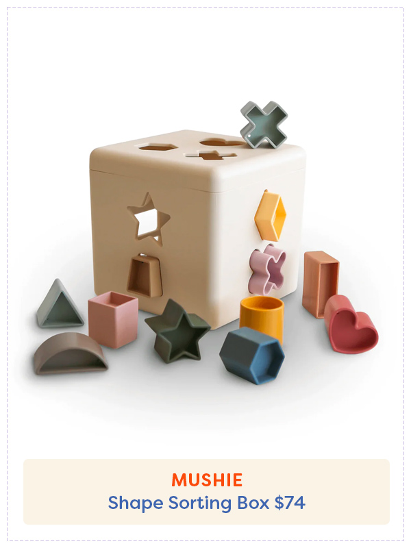 Mushie Shape Sorter with the shapes laid around the wooden block