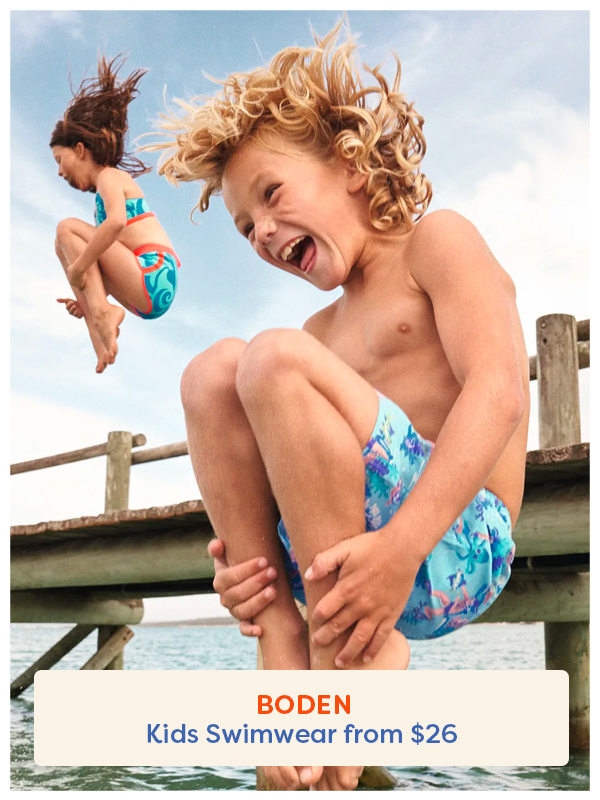 boy jumping of the jetty in boden boardshorts