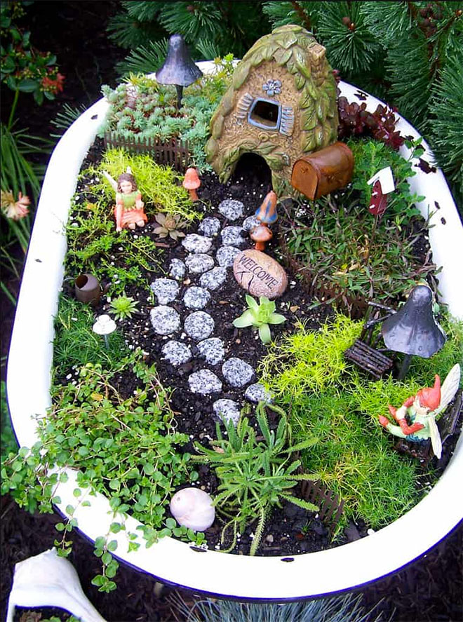 A fairy garden put together in a repurposed baby bath tub