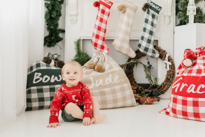 Image showing a child surrounded by Namely Co Personalised Santa Sacks