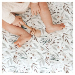 Child sitting on the Bambella Designs waterproof cot sheets