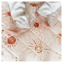 Child laying on the Bambella Designs waterproof cot sheets