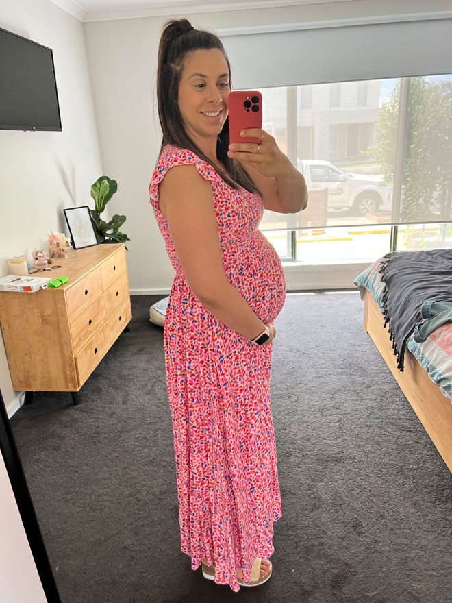 Laura shows off her pregnant belly in a pink dress