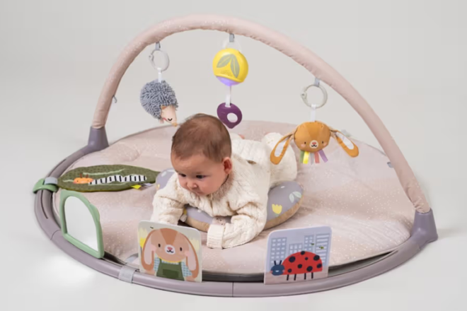 Baby lying on a Taf Toys Tummy Time Activity Gym